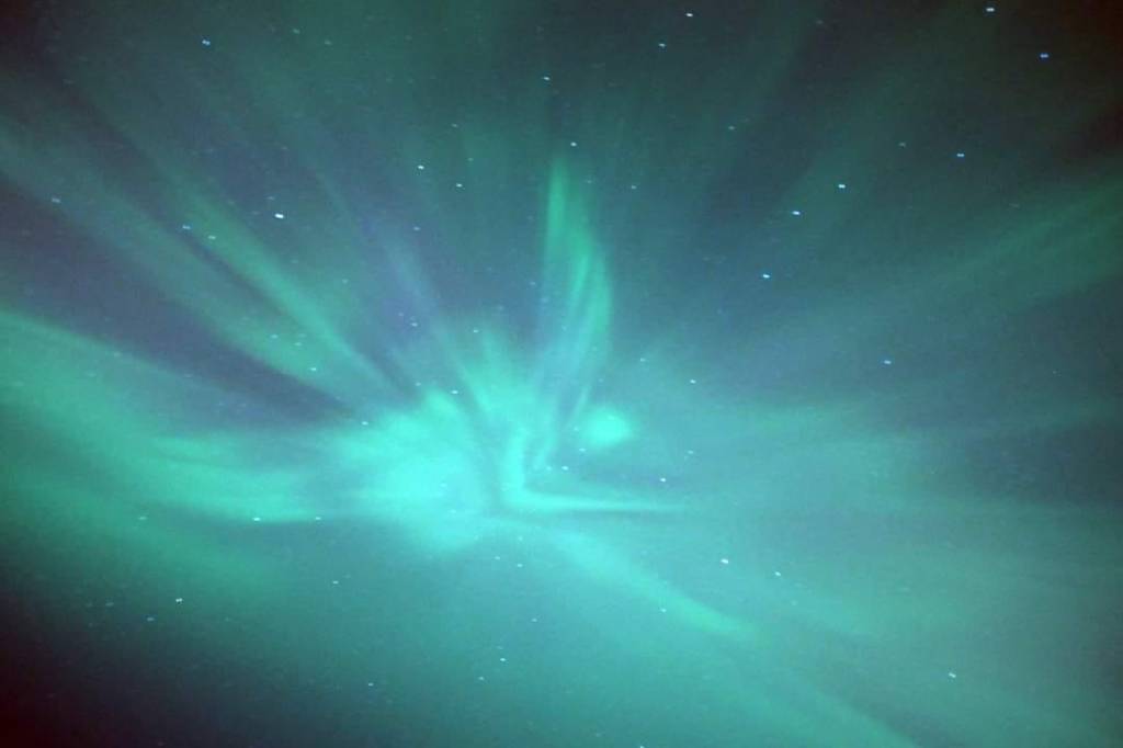 Photo of a corona formation of the Aurora shaped like an angel overhead in the sky.