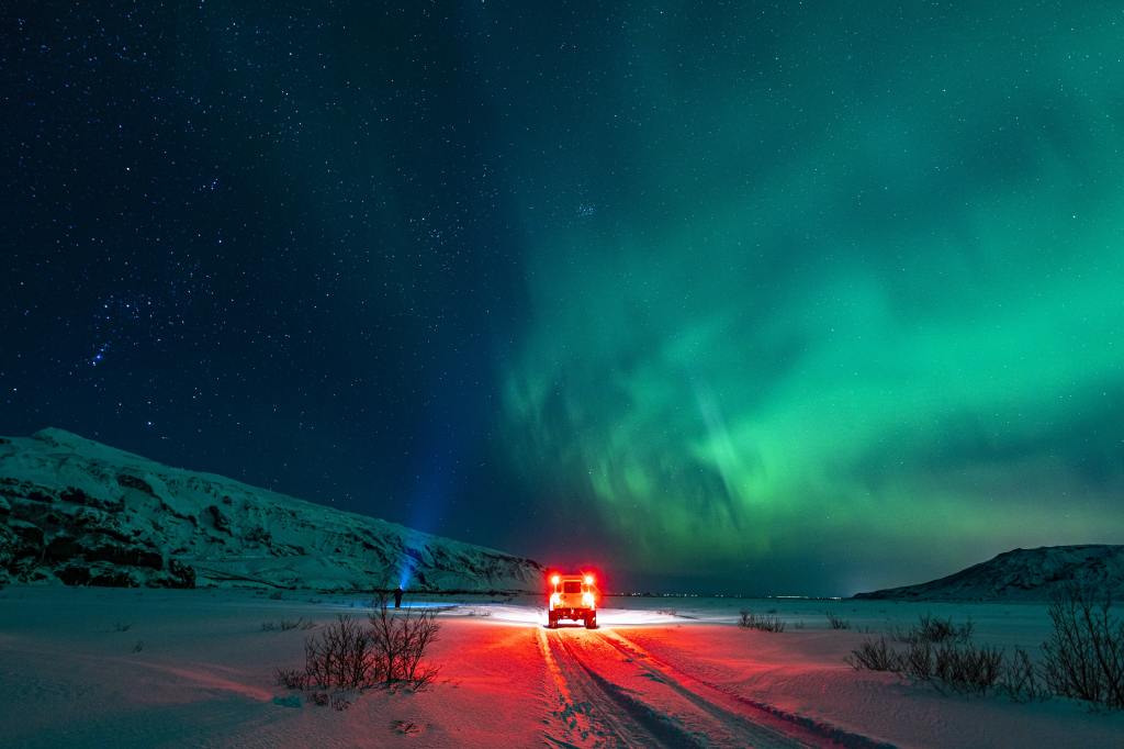 Photo of Aurora, a person and a car, by Jonatan Pie.